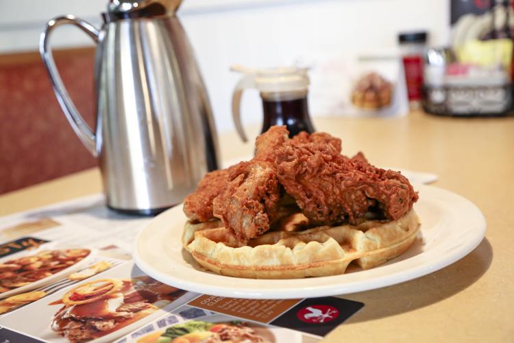Fried chicken on a waffle served with syrup at Country Kitchen Food