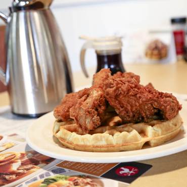 Fried chicken on a waffle served with syrup at Country Kitchen Food