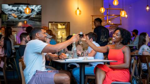"A couple enjoying a meal together and raising their glasses in a toast at Stella Luna Restaurant in Big Bear"