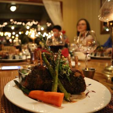A steak sits on a plat with a carrot and asparagus at a fine dining restaurant in Big Bear Lake, CA.