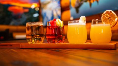 A photo of Moonridge Coffee Company's Mimosa flights - four of the mimosas are laid out on a wooden serving tray.