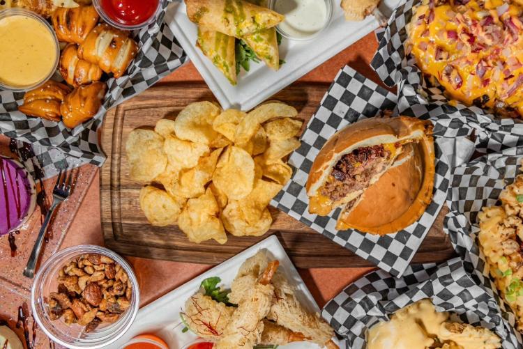 A top-down view of the Moonridge Room's food spread - there are appetizers surrounding a UFO / saucer shaped burger.