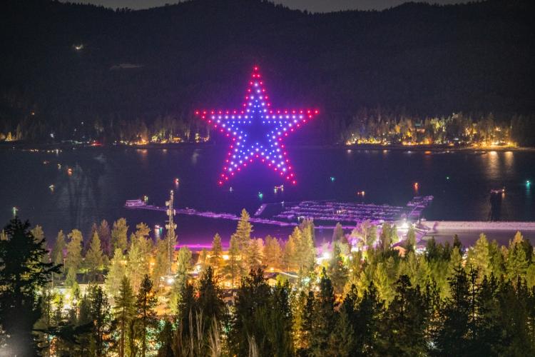 A photo taken from a distance during the Big Bear Lake Memorial Day Drone Show, there are drones making an outline of a star.