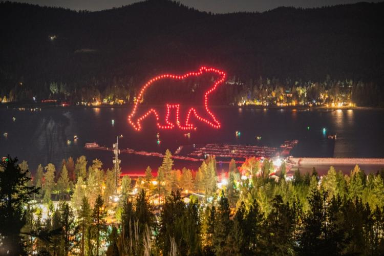 A photo taken from a distance during the Big Bear Lake Memorial Day Drone Show, there are drones making an outline of a bear.