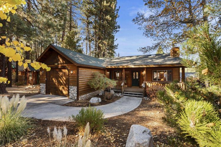 A photo of a wooden lodge cabin nestled in the forest by Big Bear Cool Cabins.