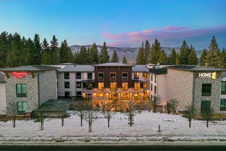 An overhead drone shot of Hampton Inn's / Home2 Suites' main building - there is snow in the front of the building.