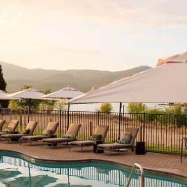 A photo of the pool view at Hotel Marina Riviera, in the background Big Bear Lake is visible along with a gentle sunset.