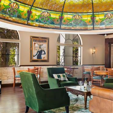 An interior shot of Tiffany's Bistro at Chateau Big Bear - there are fabric and leather chairs seen under their Tiffany Dome.