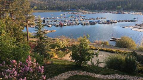 An overhead view of the Big Bear Lakefront, in the distance one of the Marinas is visible along with mountains in the back.